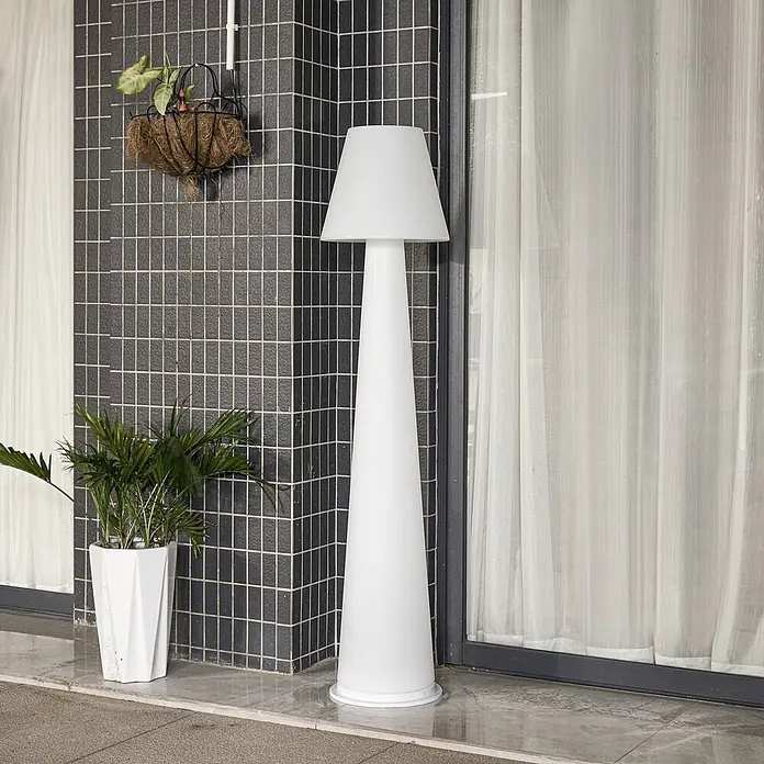 Lucande Außenstehleuchte Gauri -  - Weiße, konische Außenstehlampe mit klassischem Lampenschirm, auf einer Terrasse neben einer Fliesenwand.