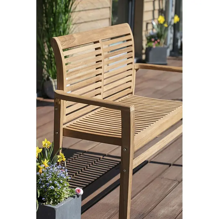 Bene Living Gartenbank Derby - B x T x H: 120 x 48 x 89 cm, Teakholz, Natur, Stapelbar - Gartenbank aus Holz mit Lattenrücken und Sitzfläche auf einer Holzterrasse, umgeben von Topfpflanzen.