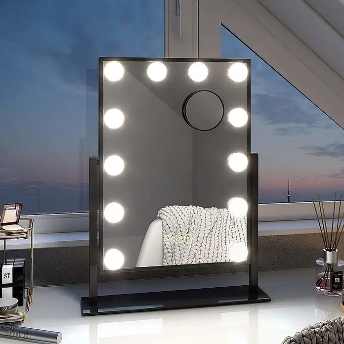 Emke Kosmetikspiegel CM12 - 36,5 x 47,5 cm, Rechteckig, Schwarz - Schwarzer Kosmetikspiegel mit LED-Beleuchtung und kleinem Vergrößerungsspiegel, auf einem Tisch am Fenster.