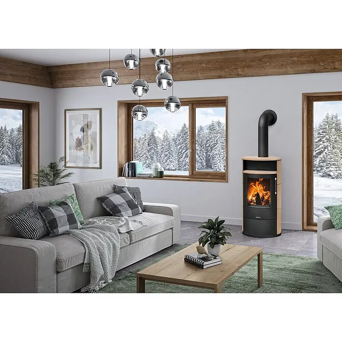 Justus Kaminofen Island 7 2.0 - 7 kW, Raumheizvermögen: 144 m³, Farbe Verkleidung: Coretto - Moderner Kaminofen mit schwarzem Brennraum und hellen Holzseiten, brennt hell in einem gemütlichen Wohnzimmer.