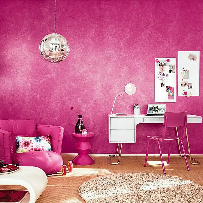 SCHÖNER WOHNEN-Farbe Trendstruktur Farbeffektputz Glimmer-Optik Effektlasur - Silber, Schimmernd, 1 l - Ein fuchsiafarbenes Zimmer mit Sessel, Schreibtisch und Diskokugel. Der Schreibtisch ist weiß mit rosa Akzenten und die Wände sind in einem satten Fuchsia gestrichen.