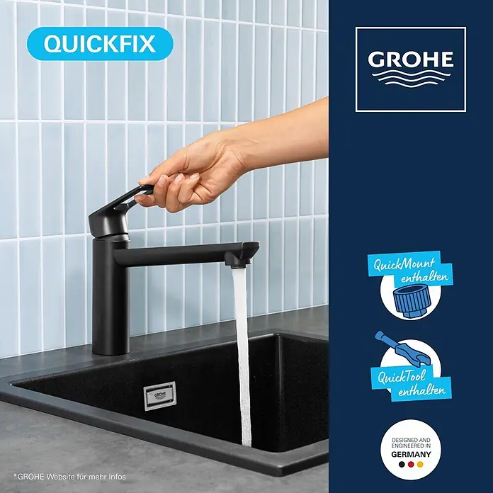 Grohe Start Loop Spültischarmatur - Ausladung Armatur: 222 mm, Schwarz, Matt - Eine Hand bedient eine mattschwarze Küchenarmatur, aus der Wasser in eine passende schwarze Spüle fließt.