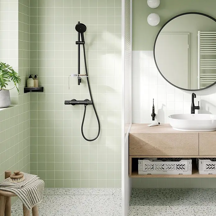 Grohe Vitalio Joy Brausearmatur 120 - Schwarz, Durchflussmenge: 6,3 l/min - Modernes Bad mit schwarzem Duschsystem, Waschtisch aus Holz mit weißem Waschbecken und schwarzem Wasserhahn, sowie rundem Spiegel.