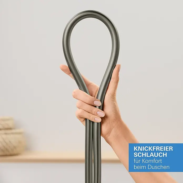 Grohe Brauseschlauch Silverflex - Länge: 125 cm, ½″, Kunststoff, Hard Graphite - Eine Hand hält einen flexiblen, dunkelgrauen Knickfrei-Duschschlauch in einer Schlaufe, der Komfort beim Duschen zeigt.