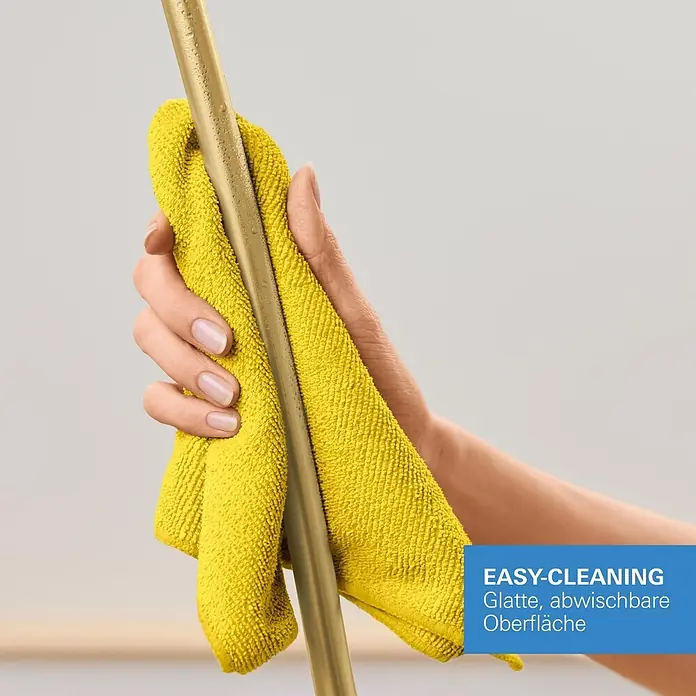 Grohe Brauseschlauch Silverflex - Länge: 125 cm, ½″, Kunststoff, Cool Sunrise - Eine Hand wischt mit gelbem Tuch Wassertropfen von einem goldfarbenen Rohr, hebt die leicht abwischbare Oberfläche hervor.