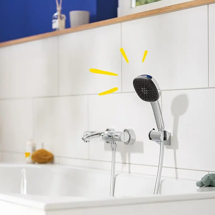 Grohe Vitalio Comfort Handbrause 110 - Anzahl Funktionen: 3 Stk., Durchmesser: 110 mm, Chrom - Verchromte Brause und passende Badewannenarmatur über einer weißen Badewanne in einem modernen Bad.