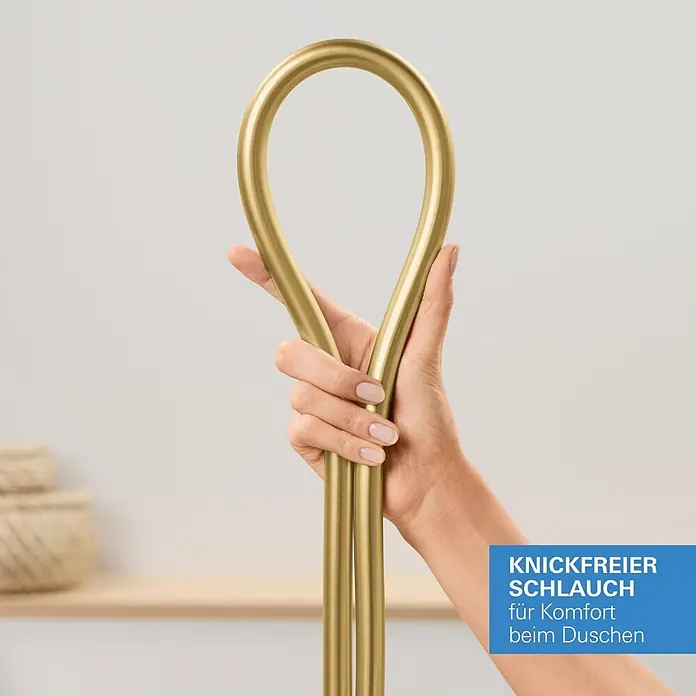 Grohe Brauseschlauch Silverflex - Länge: 125 cm, ½″, Kunststoff, Cool Sunrise - Goldener, knickfreier Duschschlauch, von einer Hand gehalten und gebogen, um seine Flexibilität zu zeigen.