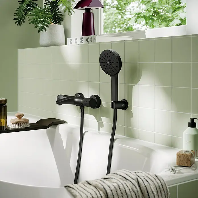 Grohe Vitalio Joy Handbrause 120 - Anzahl Funktionen: 3 Stk., Durchmesser: 120 mm, Mattschwarz - Mattschwarzer Grohe Thermostat-Brausemischer und Handbrause über einer weißen Badewanne.