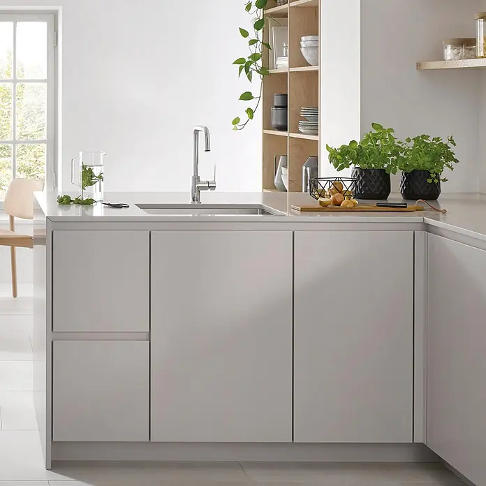Grohe Start Spültischarmatur - Chrom, Glänzend - Moderne hellgraue Küche mit weißer Arbeitsplatte, integrierter Spüle, Chromarmatur, Holzregalen und Topfkräutern.