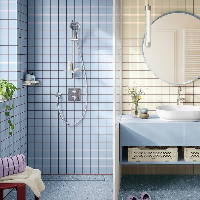 Grohe Vitalio Joy Brausearmatur 120 - Chrom, Durchflussmenge: 6,3 l/min - Modernes Badezimmer mit hellblauen und cremefarbenen Fliesen, roter Fuge, Chromdusche, hellblauem Waschtisch, weißem Waschbecken und rundem Spiegel.