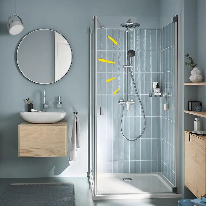 Grohe Vitalio Start Duschsystem 250 - Höhe: 112 cm, Lochabstand: 101 cm, Anzahl Strahlarten: 2 Stk., Chrom - Duschkabine aus Klarglas mit Chromrahmen, installiert in einem modernen Badezimmer mit blauen Fliesen.
