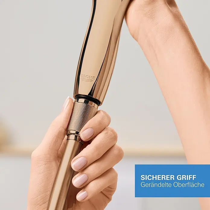 Grohe Brauseschlauch Silverflex - Länge: 125 cm, ½″, Kunststoff, Warm Sunset - Eine Hand hält eine roségoldene Grohe Handbrause mit gerändeltem Griff für sicheren Halt.