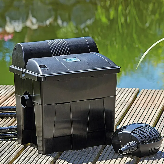 Oase BioSmart Sistema de filtro para estanque BioSmart 5000 - 25 W, Dimensión de estanque: 5 m³ - Un filtro de estanque Oase y una bomba se asientan en un muelle de madera. Este sistema de filtración es esencial para agua limpia.