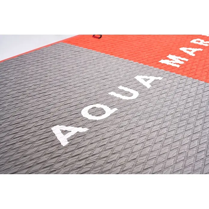 Aqua Marina SUP-Board-Set Atlas - L x B x H: 366 x 86 x 15 cm, Tragkraft: 180 kg, Orange - Nahaufnahme des grauen, texturierten Deckpads eines Stand-Up-Paddleboards mit weißen "AQUA"-Buchstaben und einem roten Bereich mit "MAR"-Text.