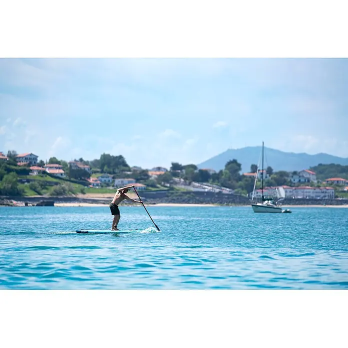 Aqua Marina SUP-Board Vapor - L x B x H: 315 x 79 x 15 cm, Nutzlast: 140 kg, Aufblasbar - Mann paddelt auf hellblauem Board mit schwarzem/rotem Paddel im Wasser.