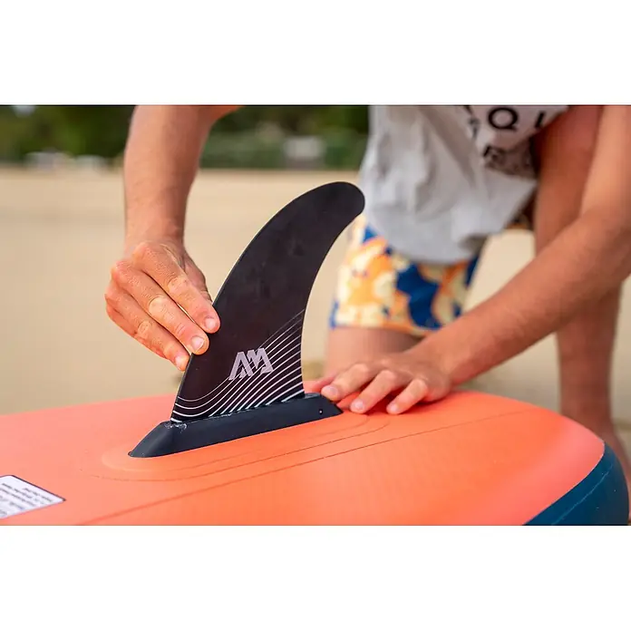 Aqua Marina SUP-Board-Set Atlas - L x B x H: 366 x 86 x 15 cm, Tragkraft: 180 kg, Orange - Person montiert eine schwarze Stand-Up-Paddle-Finne mit weißem Logo in ein orangefarbenes Paddleboard.