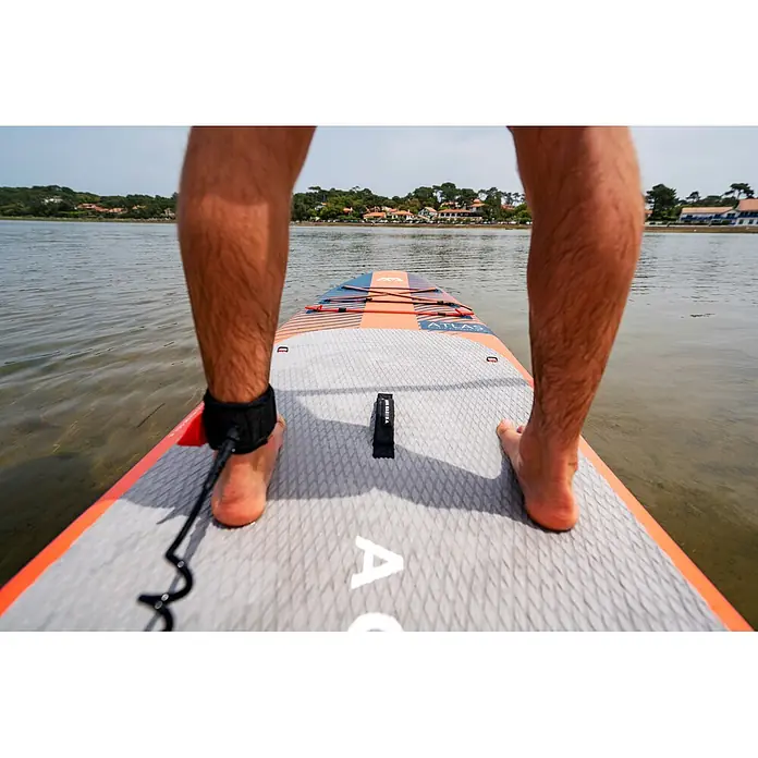 Aqua Marina SUP-Board-Set Atlas - L x B x H: 366 x 86 x 15 cm, Tragkraft: 180 kg, Orange - Eine Person steht auf einem orange-blauen und grauen Aqua Marina Atlas Paddleboard auf dem Wasser, mit texturiertem Deckpad und Knöchelleine.