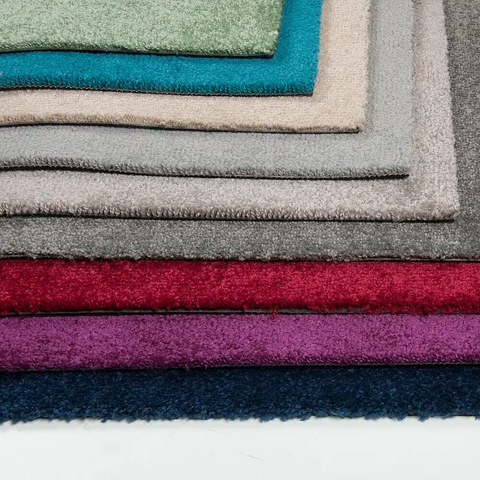 Bricoflor Teppichfliese Velours Hochflor, Hell-Grau, 50 - Breite: 50 cm, Velours, 100 % Polypropylen (PP), Hell-Grau - Stapel Teppichmuster in verschiedenen Farben (Grün, Blau, Beige, Grau, Rot, Violett), zeigt ihre weiche, texturierte Oberfläche.