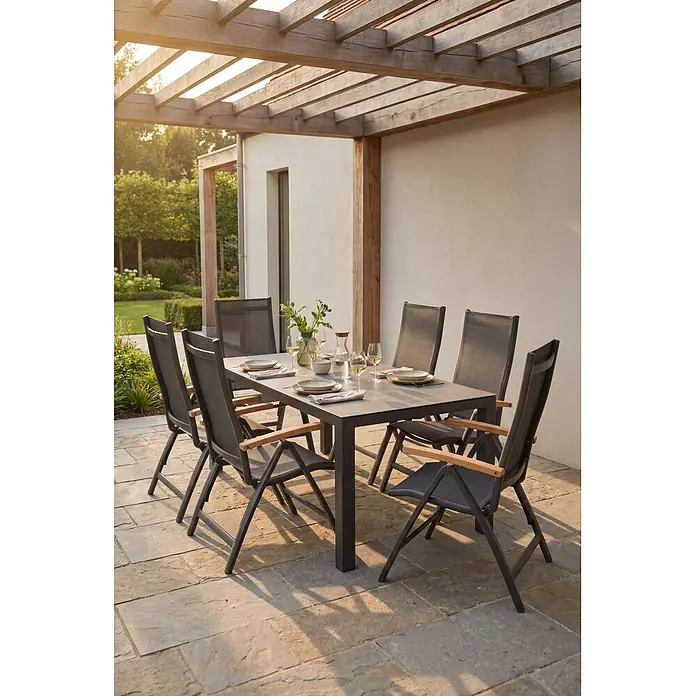 Barths Garten-Positionssessel Paros - Aluminium, Textilene, Anthrazit, B x T x H: 62 x 67 x 110 cm - Outdoor-Essgruppe: ein dunkelgrauer Tisch mit sechs passenden Stühlen mit Holzarmlehnen, auf einer Terrasse unter einer Holzpergola.