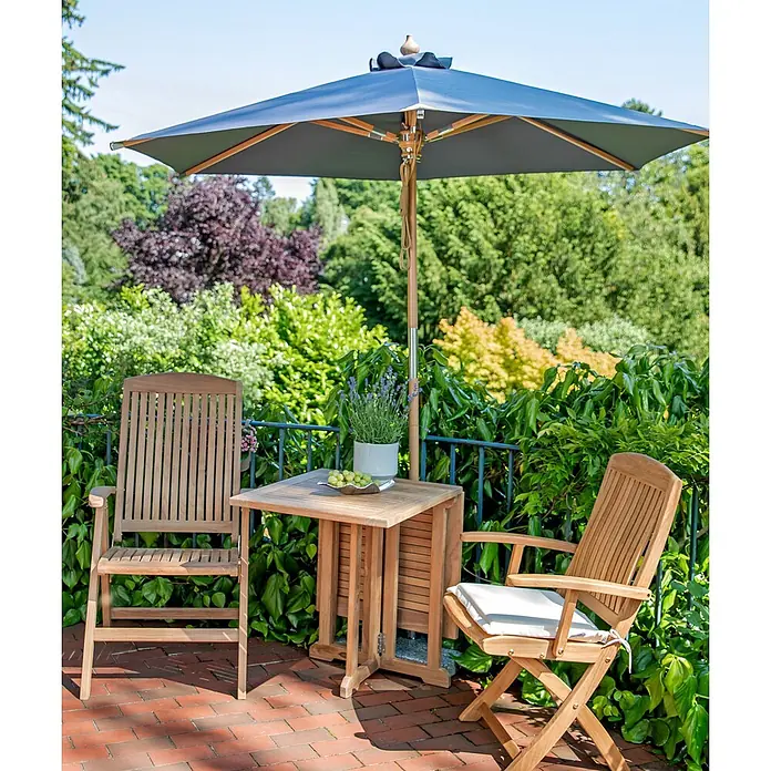 Kai Wiechmann Marktschirm Sunshine Style 240 cm Anthrazit - Grau|Anthrazit - Hölzernes Outdoor-Esstisch-Set mit klappbarem Tisch, zwei Stühlen und einem dunkelgrauen Sonnenschirm auf einer Backsteinterrasse.