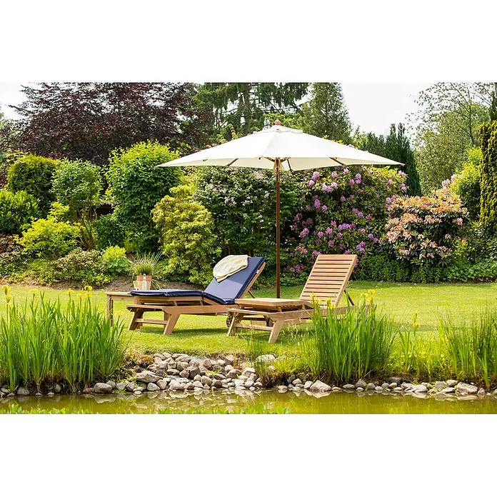 Kai Wiechmann Marktschirm Mittelmastschirm quadratisch 250 cm Weiß - Weiß|Altweiß|Ecru|Natur|Beige|Creme - Zwei hölzerne Sonnenliegen mit Beistelltisch und weißem Sonnenschirm auf einem Rasen am Teich. Eine Liege hat ein blaues Kissen.