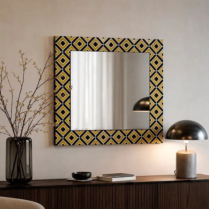 Espejo de pared Retro - 60 x 60 cm, Amarillo/Negro - Espejo cuadrado con marco de patrón geométrico negro y dorado, colgado sobre una consola.