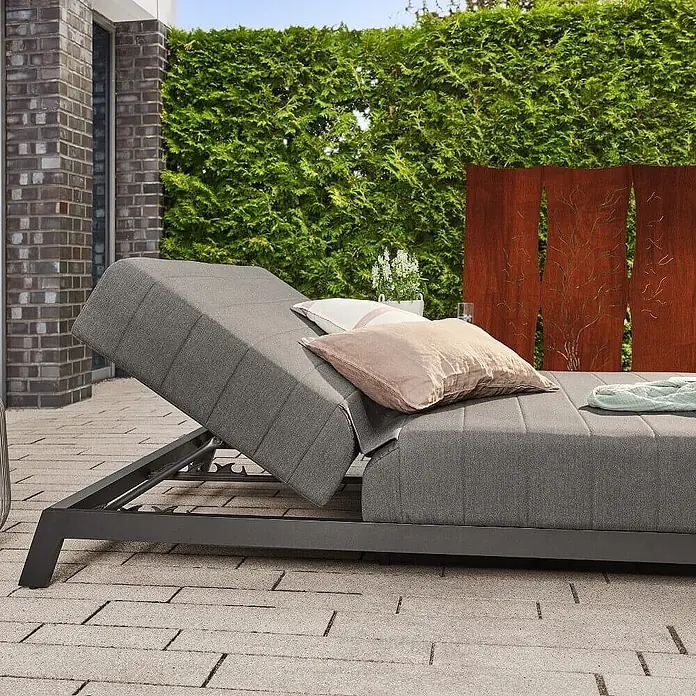 Home Deluxe Gartenliege VALENCIA - Grau, Sonstiges - Verstellbare graue Sonnenliege mit Kissen auf einer Außenterrasse.