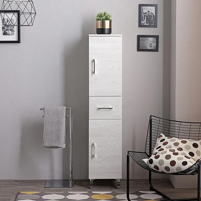 Kiamami Valentina Badmöbel-Set - Helles Holz - Hoher weißer Holzschrank mit Chromgriffen und -füßen in moderner Raumumgebung.