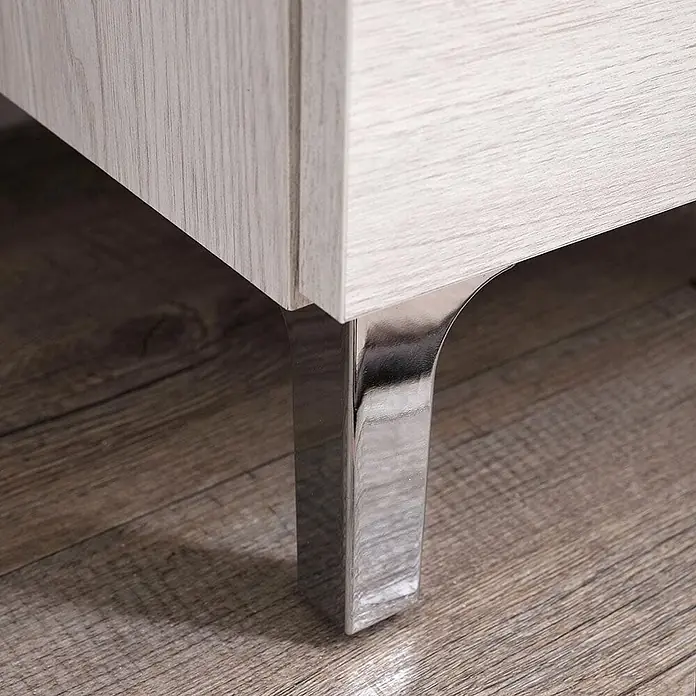 Kiamami Valentina Badmöbel-Set - Weiß - Eleganter Chrom-Möbelfuß, der einen hellen Holzschrank auf einem Holzboden stützt.