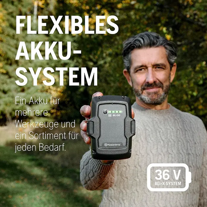 Husqvarna Akku-Rasenmäher LB144i (ohne Akku) - 36 V, Ohne Akku, Schnittbreite: 440 mm - Mann hält eine schwarze Husqvarna BLi-X 36V Batterie im Freien, präsentiert flexibles System für mehrere Werkzeuge.