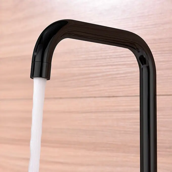 Poalgi Spültischarmatur Comfort - Kristallschwarz, Glänzend - Schwarze Hochglanz-Küchenarmatur mit fließendem Wasser, vor Holzhintergrund.
