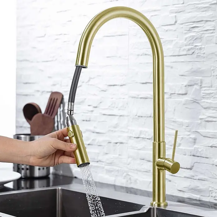Poalgi Spültischarmatur Space - Goldfarben, Seidenmatt - Goldfarbene ausziehbare Küchenarmatur mit Brausekopf in Gebrauch, Wasser fließt in ein Spülbecken.