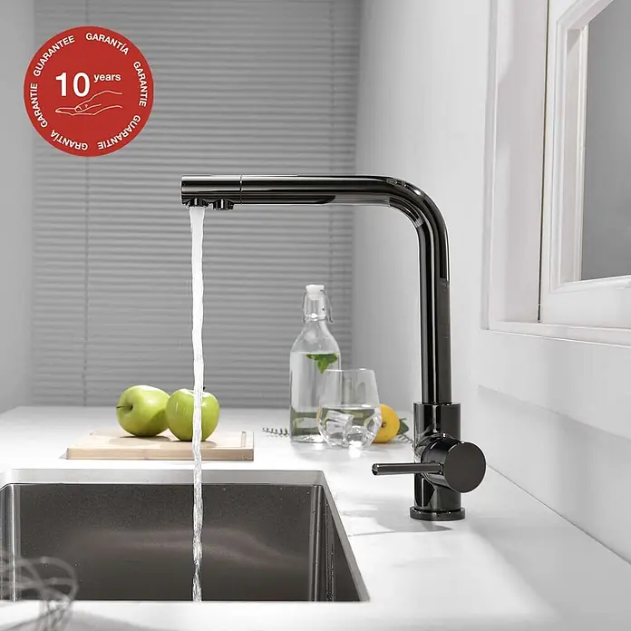 Poalgi Spültischarmatur Life - Kristallschwarz, Glänzend - Elegante schwarze Küchenarmatur mit fließendem Wasser über einem Spülbecken, umgeben von frischen Lebensmitteln und Getränken.