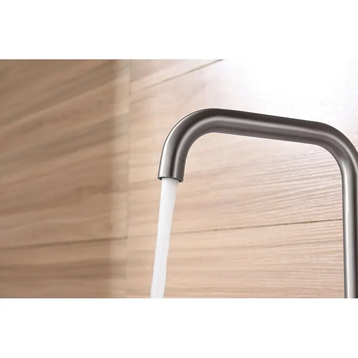 Poalgi Spültischarmatur Comfort - Nickel, Seidenmatt - Armatur aus gebürstetem Metall mit fließendem Wasser vor einer hellen Holzwand.