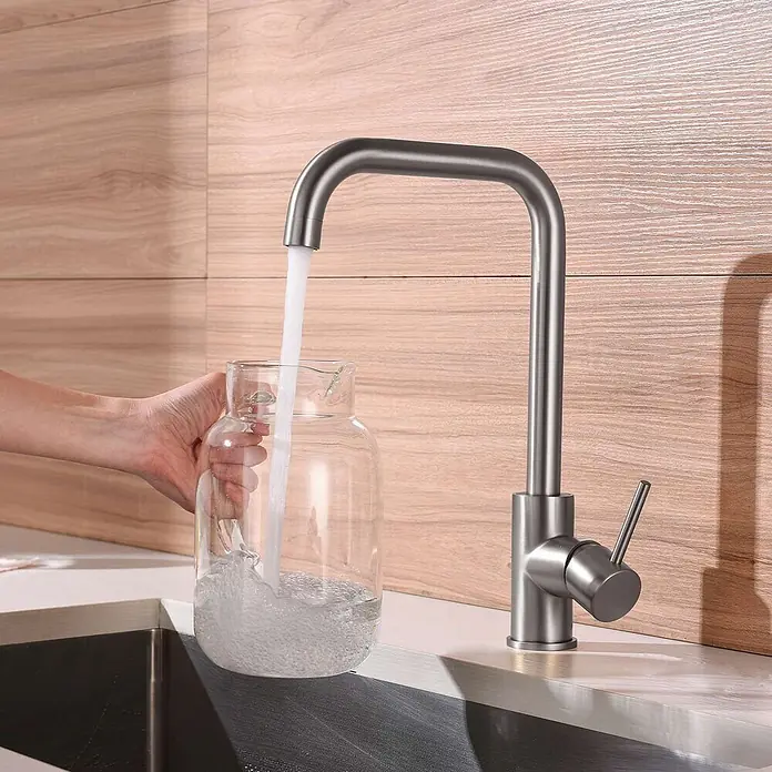 Poalgi Spültischarmatur Comfort - Nickel, Seidenmatt - Gebürstete Edelstahl-Küchenarmatur mit U-förmigem Auslauf, die Wasser in ein Glasgefäß im modernen Spülbecken füllt.