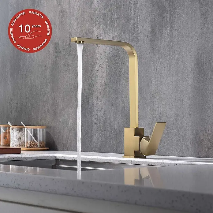 Poalgi Spültischarmatur Cross - Goldfarben, Seidenmatt - Gebürstete goldene Küchenarmatur mit Wasser, das in ein modernes Spülbecken auf einer Arbeitsplatte läuft.