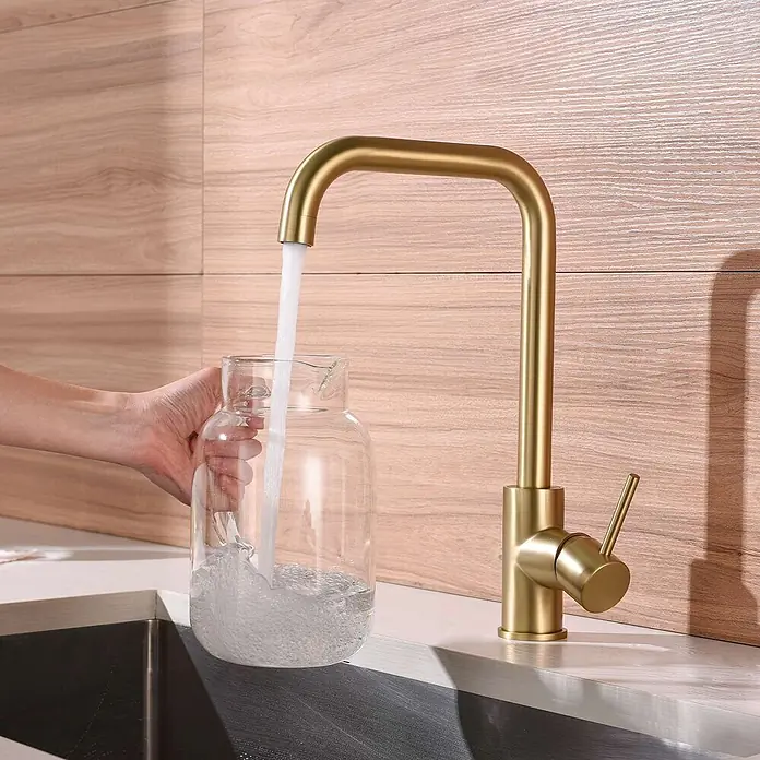 Poalgi Spültischarmatur Comfort - Goldfarben, Seidenmatt - Goldener Küchenarmatur mit gebogenem Auslauf, füllt Wasser in ein Glasgefäß in moderner Küchenumgebung.