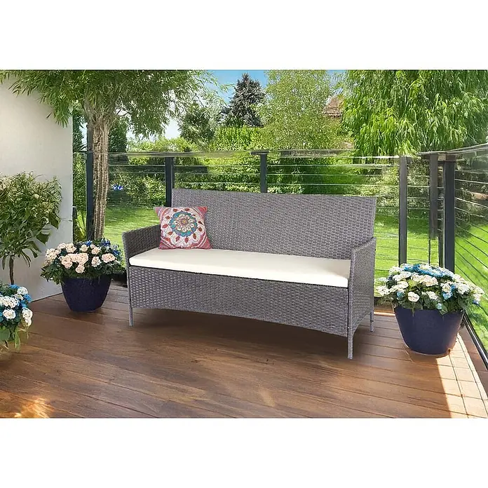 Proregal Gartenbank 3-Sitzer Kissen Creme - Polyester, Grau - Graue Outdoor-Sitzbank aus Rattan mit cremefarbenem Kissen und Zierkissen auf einer Holzterrasse.