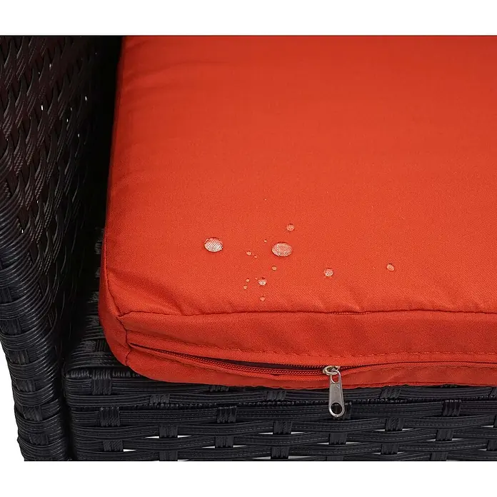 Proregal Gartenbank Kissen Terrakotta - Polyester, Schwarz - Nahaufnahme eines orangefarbenen, wasserabweisenden Kissens mit Wassertropfen und Reißverschluss auf schwarzen Korbmöbeln.