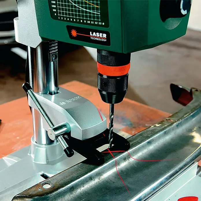 Bosch Tischbohrmaschine PBD 40 - Hub: 90 mm - Nahaufnahme einer Bosch PBD 40 Tischbohrmaschine beim Bohren in ein Metallstück, mit Lasertechnologie zur präzisen Positionierung.