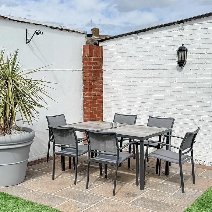 Outsunny Gartentisch-Set - Gesamtumfang: 7 -tlg., L x B x H: 150 x 87 x 72 cm, Stahl, Mesh, SPCC-Kunststoff, Stapelbar - Outdoor-Esstisch-Set mit grauem Lamellentisch und sechs dunkelgrauen Metall- und Netzstühlen auf einer Terrasse.
