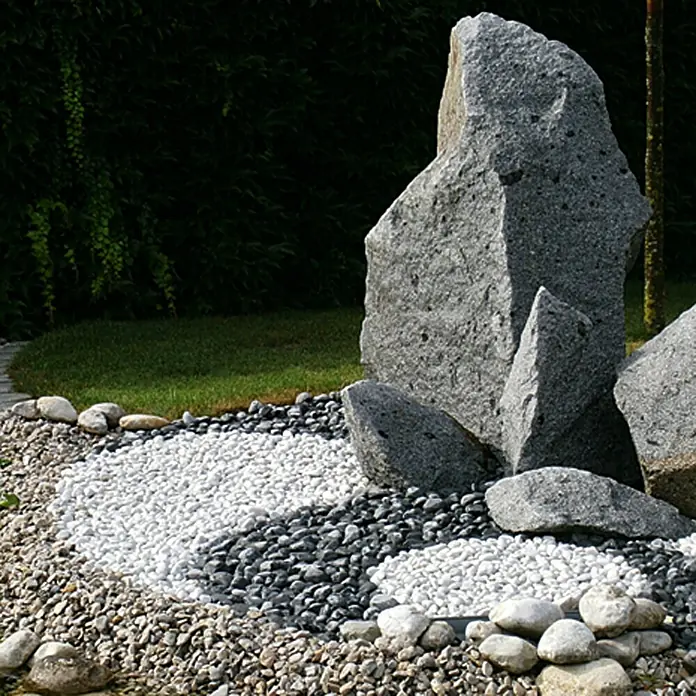 Min2C Marmorkiesel - Grün, Körnung: 15 mm - 25 mm, 25 kg - Nahaufnahme einer Zen-Garten-Skulptur mit weißen und schwarzen Kieselsteinen, die eine friedliche und harmonische Atmosphäre schaffen.