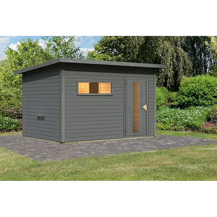 Karibu Saunahaus Hytti 6 - Ohne Ofen, Terragrau, L x B x H: 231 x 396 x 217 cm - Dunkelgraues Holzgartenhaus mit Fenster und Tür, auf einer Steinpflasterung.