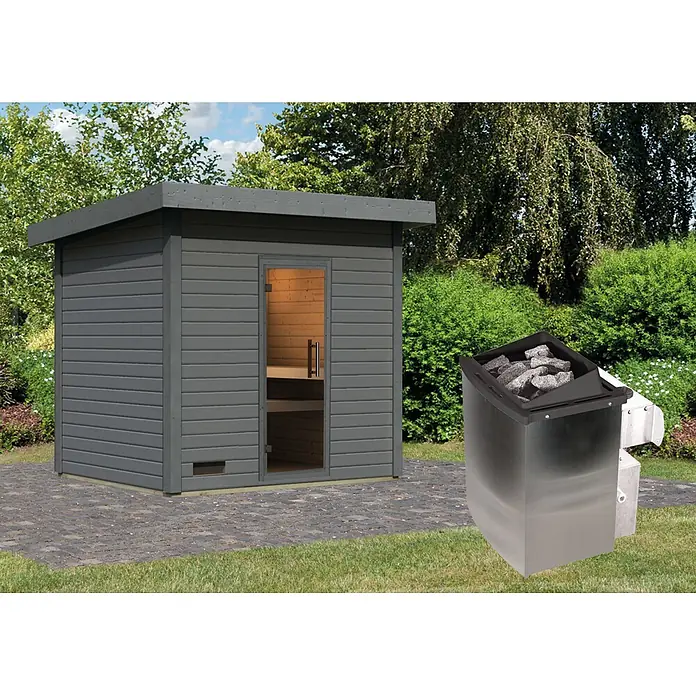 Karibu Saunahaus Kaapi 4 - 9 KW Ofen mit interner Steuerung, Anthrazit, L x B x H: 196 x 231 x 238 cm - Graue Holz-Außensauna auf gepflasterter Terrasse mit Edelstahl-Saunaofen und schwarzen Saunasteinen.