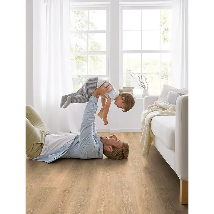 Decolife Designboden Freestyle - Oak Rustic Chalk, Landhausdiele, 1.220 x 185 x 8 mm - Heller Holzfußboden in einem Wohnzimmer, auf dem Vater und Sohn spielen.