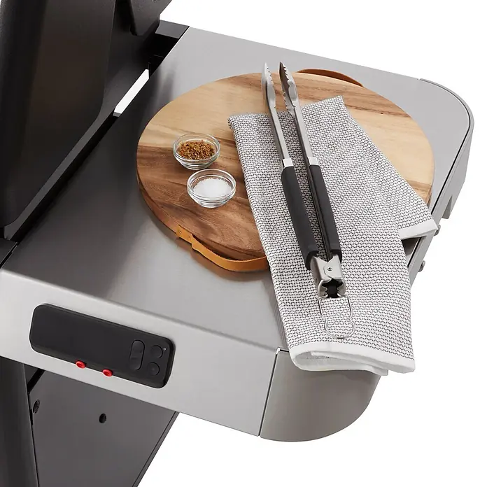 Weber Gasgrill Genesis EX-325S - Grillfläche (B x T): 68 x 48 cm, 11,4 kW, Anzahl Brenner: 3 Stk. - Edelstahl-Grillseitenablage mit Steuerung, darauf Schneidebrett, Zange, Gewürze und Tuch zur Essenszubereitung.
