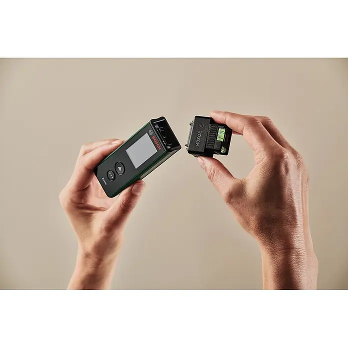 Bosch Laserentfernungsmesser Zamo Set - Messbereich: 0,15 - 40 m, 7 -tlg. - Zwei Hände halten ein schwarz-grünes Bosch Zamo Lasermessgerät und dessen schwarzes Neigungsmodul, scheinbar beim Verbinden.