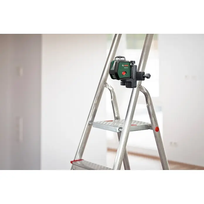 Bosch Kreuzlinienlaser PLL360-15G Premium Set - Max. Arbeitsbereich: 30 m, 3,6 V - Grün-schwarzer Bosch PLL 360-150 Laser-Nivellier an einer silbernen Stehleiter in einem Raum.