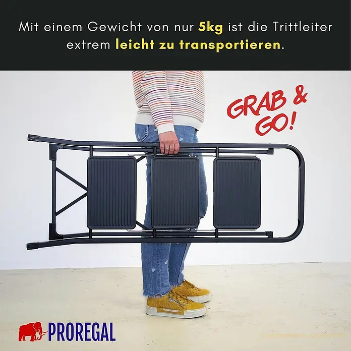 Proregal Klapptritt Trittleiter klappbar - Anzahl Tritte: 3 Stk., Belastbarkeit: 150 kg, Stahl - Eine schwarze, zusammengeklappte Trittleiter wird von einer Person getragen. Sie ist leicht und einfach zu transportieren.