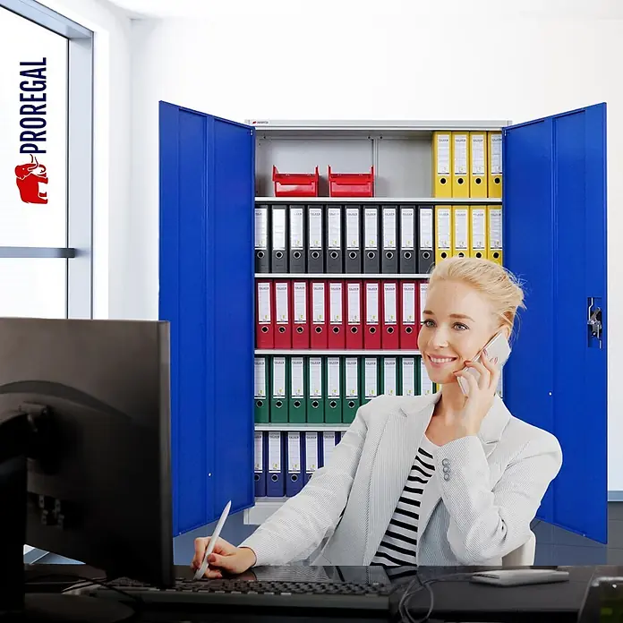 Proregal Aktenschrank ELEPHANT komplett montiert - Blau/Lichtgrau - Blauer Metall-Aktenschrank mit offenen Türen und Regalen voller bunter Ordner, prominent in einer Büroumgebung.